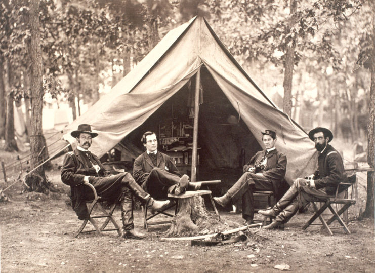 Four American Civil War-era Secret Service agents sitting near a tent