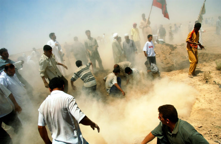 Iraqi men standing together in the sand