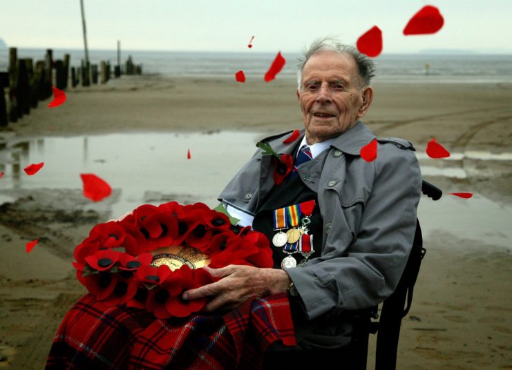 Harry Patch holding a wreath at the beach