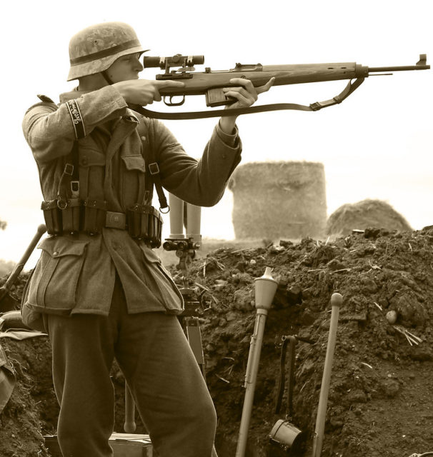 Re-enactor aiming a Gewehr 43 while dressed as a German soldier