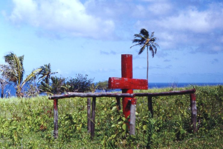 Red-painted wooden cross in the middle of an island