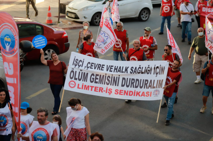 Protesters walking along a street with signs and flags