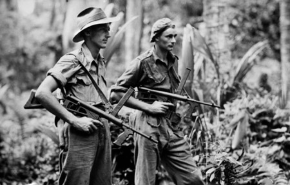 Leon Ravet and Bernard Kentwell carrying Owen guns through the jungle