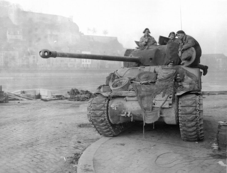 Three soldiers atop a Sherman Firefly