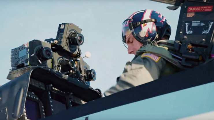 Tom Cruise sitting in the cockpit of an aircraft