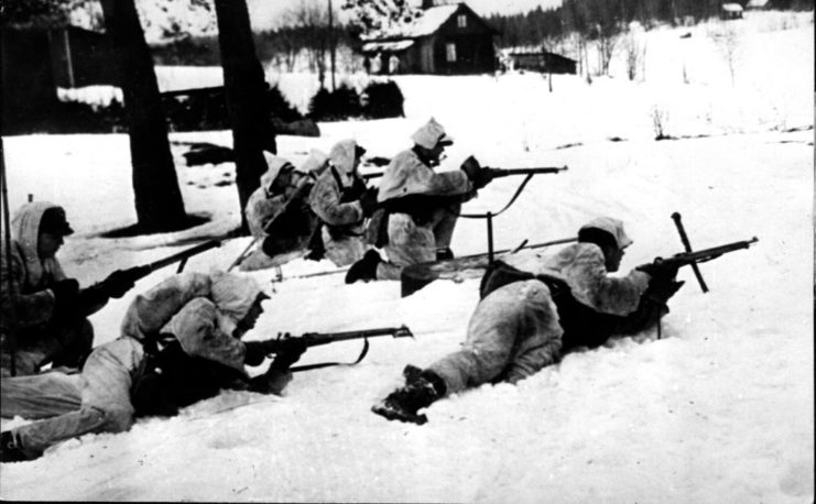 Finnish troops aiming their rifles while laying in the snow