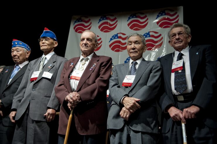 Members of the Texas Battalion and the 442nd Regimental Combat Team standing together on stage