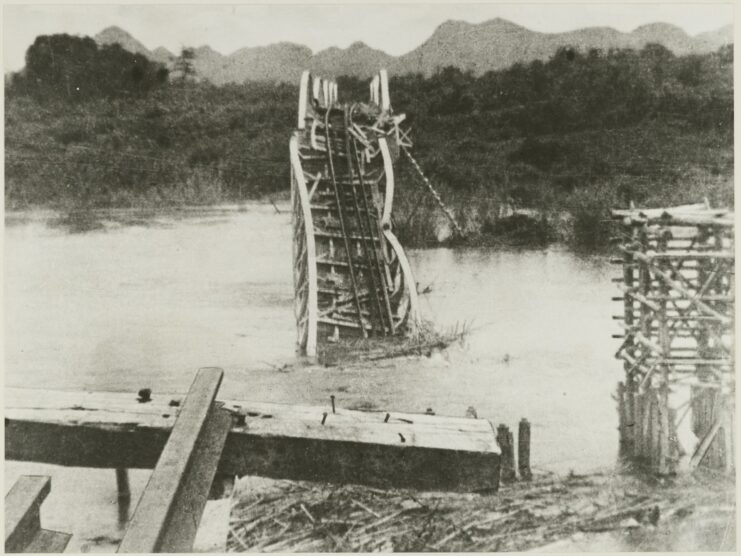 Damaged bridge half-collapsed into a river