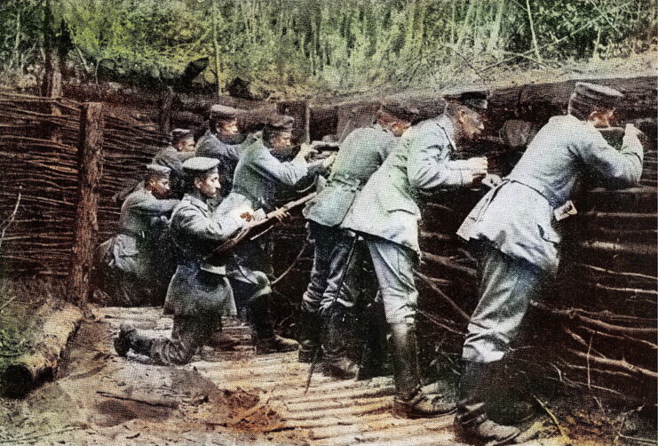 German soldiers standing in a trench fortified by tree branches and pieces of wood