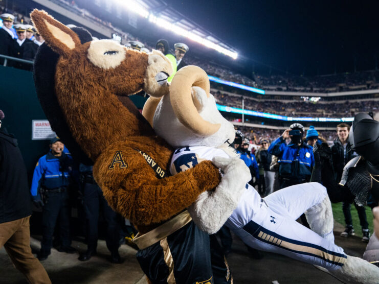 Army Black Knights mascot wrestling Bill the Goat while others watch