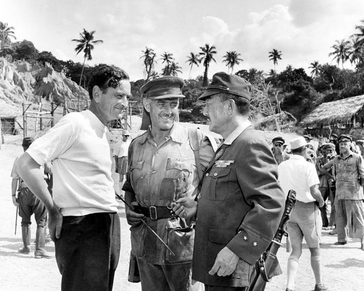 David Lean standing with Alec Guinness and Sessue Hayakawa on the set of 'The Bridge on the River Kwai'