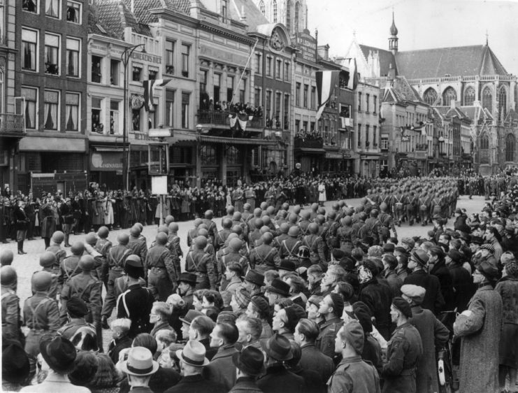 Crowd watching members of the Polish 1st Armoured Division march down a street
