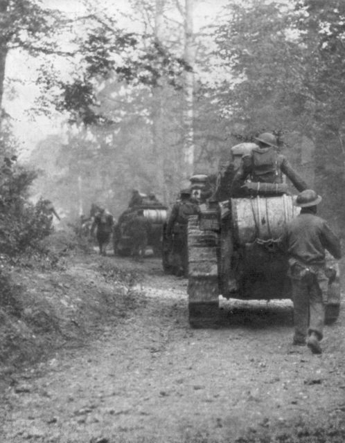 US troops and tanks traveling along a dirt road in the middle of the Forest of Argonne