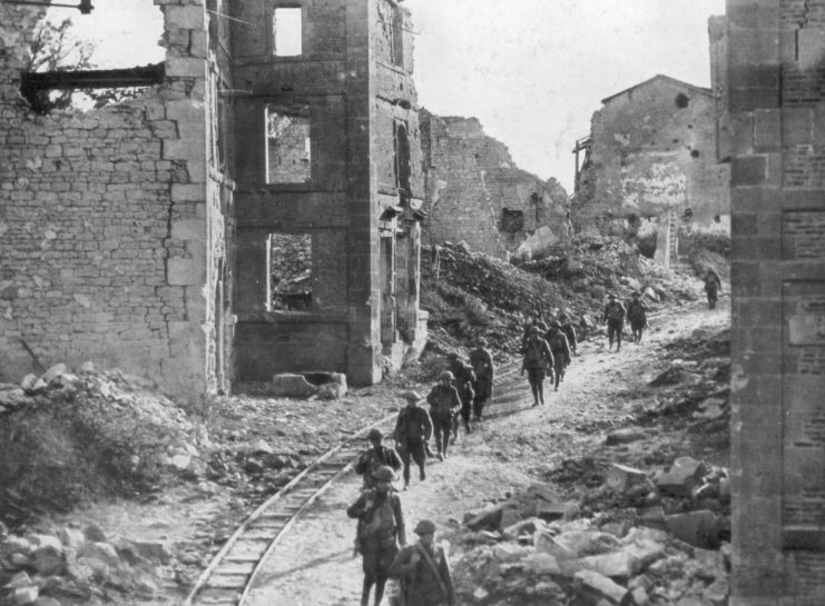 US soldiers walking along a debris-strewn street in Varennes-en-Argonne