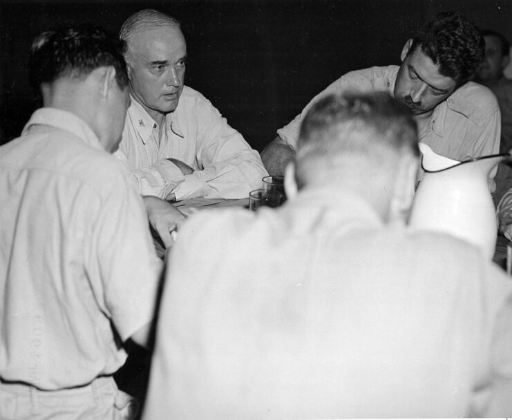 Charles McVay III sitting at a table with war correspondents