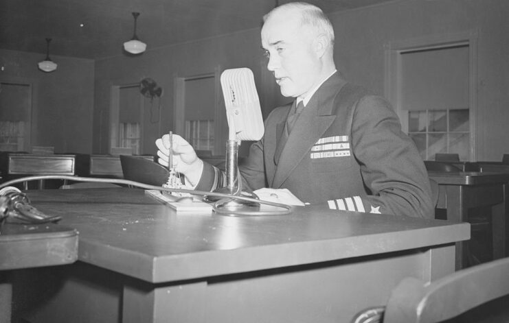 Charles McVay III speaking into a microphone while sitting at a desk