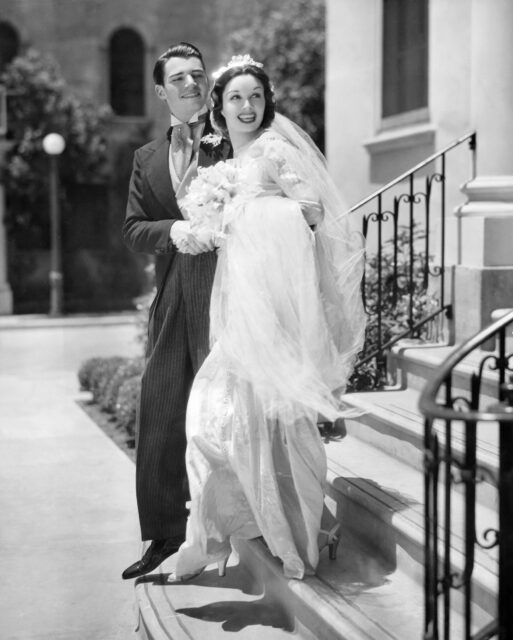William Hopper and Gail Patrick walking down a flight on stairs while dressed for a wedding