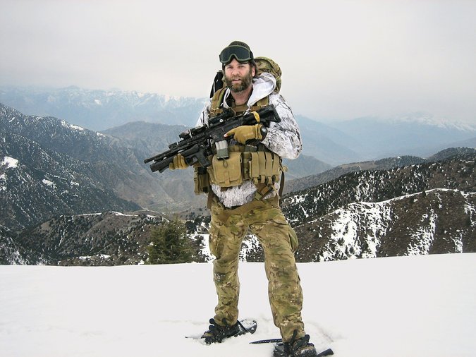 Jason Everman standing atop a snowy ridge while holding a weapon
