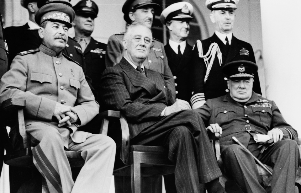 Joseph Stalin, Franklin D. Roosevelt and Winston Churchill sitting amongst military officials