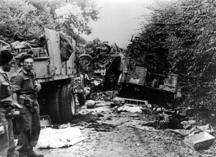 Members of the Polish 1st Armoured Division standing near damaged military vehicles