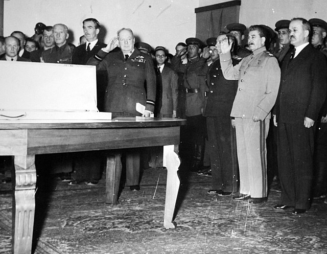 Winston Churchill, Joseph Stalin and military officials standing before the Sword of Stalingrad