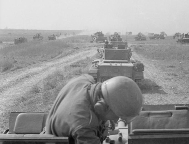 Cromwell and M4 Sherman tanks driving down a dirt road