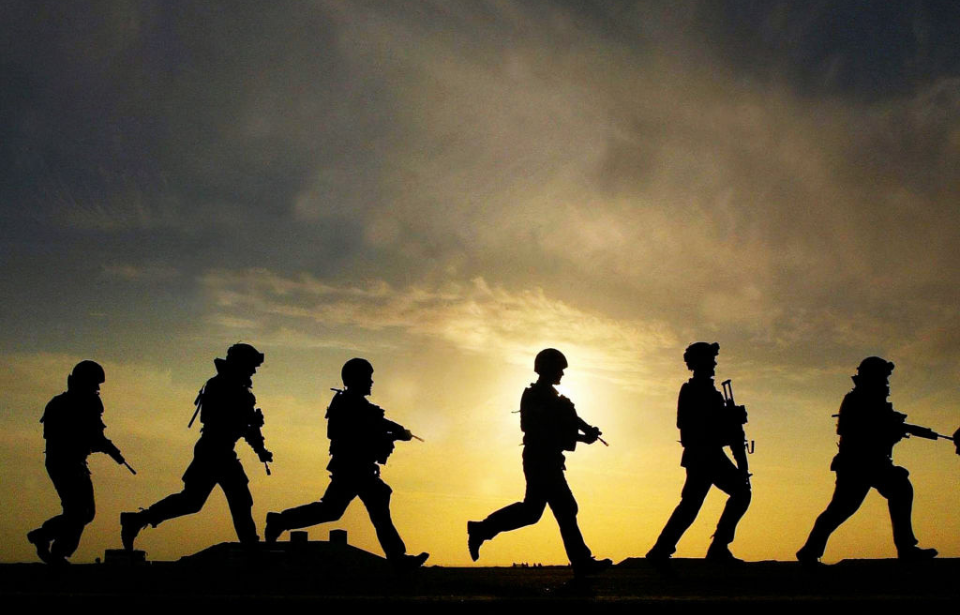 Six soldiers walking at sunset