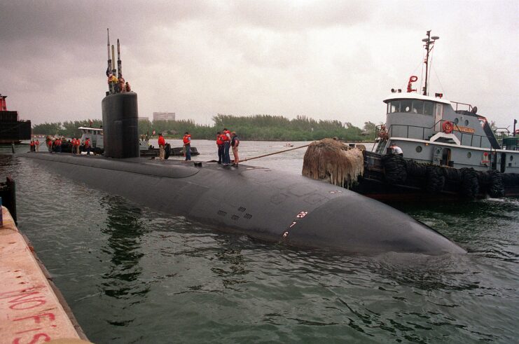 Tugboats and sailors maneuvering the USS Miami (SSN-755) to port