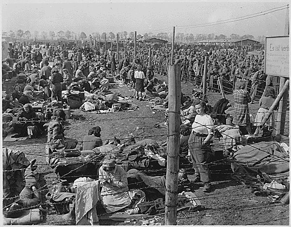 Female prisoners of war (POWs) standing near a barbed wire fence at a Rheinwiesenlager camp