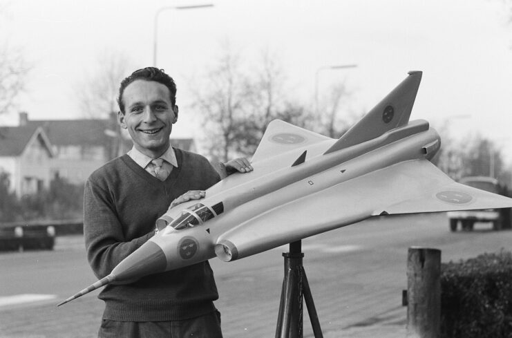 Man standing with a model of the Saab J35 Draken