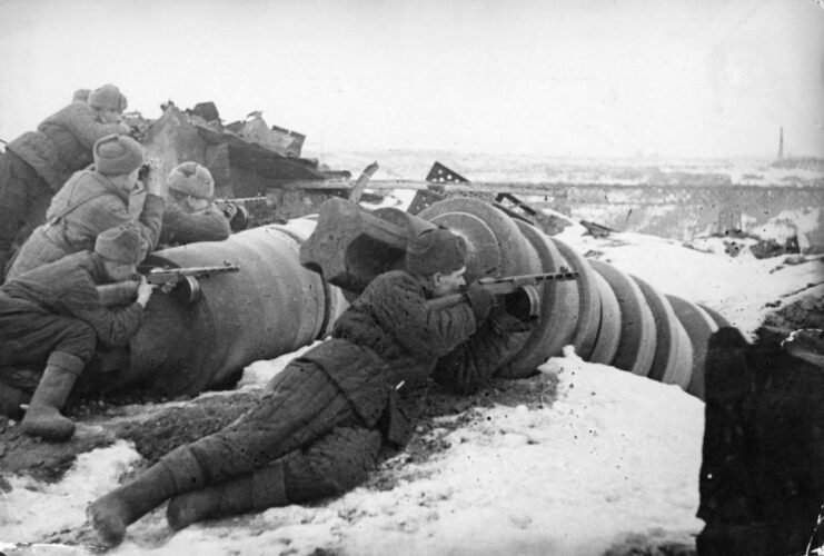 Red Army soldiers aiming rifles from behind debris