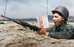 Soldier in a foxhole reading a book titled, "How to Survive an Atomic Bomb"