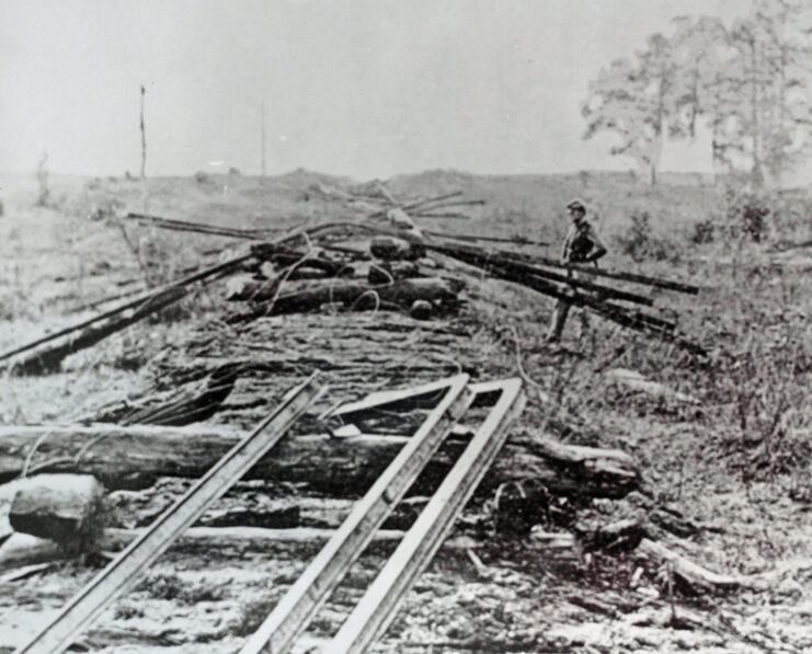 Man walking toward a destroyed Confederate railroad