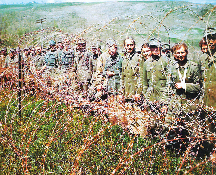 German prisoners of war (POWs) standing behind barbed wire