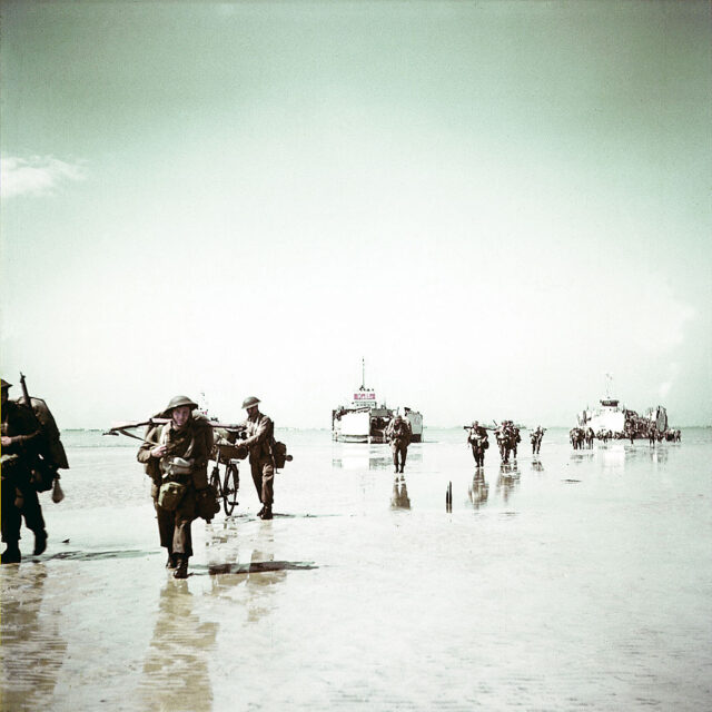 Members of the 3rd Canadian Infantry Division walking across Juno Beach