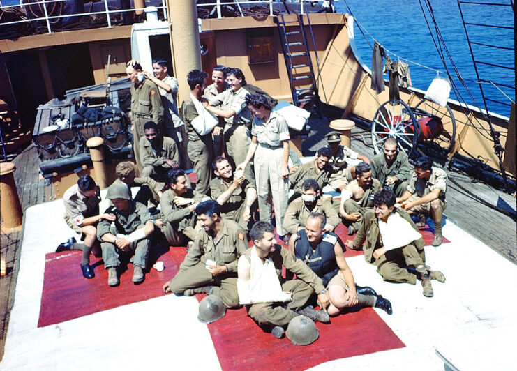 Nurses and doctors tending to wounded soldiers on the deck of a ship