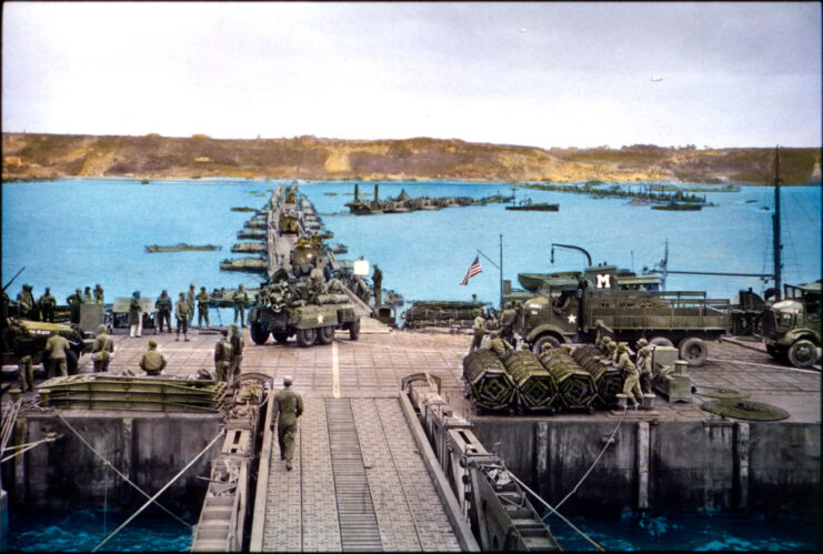 Jeeps and military vehicles driving across Pontoon Bridge, toward Temporary Mulberry Harbor A