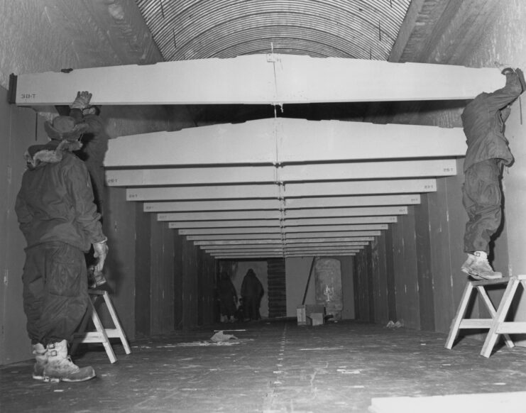US Army Polar Research and Development Center personnel standing throughout a "T5" building