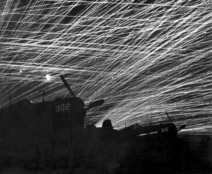 Grounded aircraft backlit by anti-aircraft fire