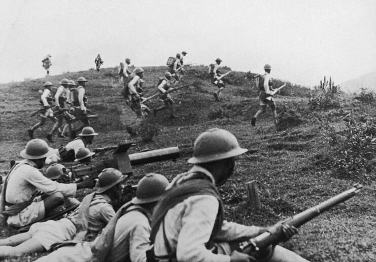 Japanese soldiers running across a hill
