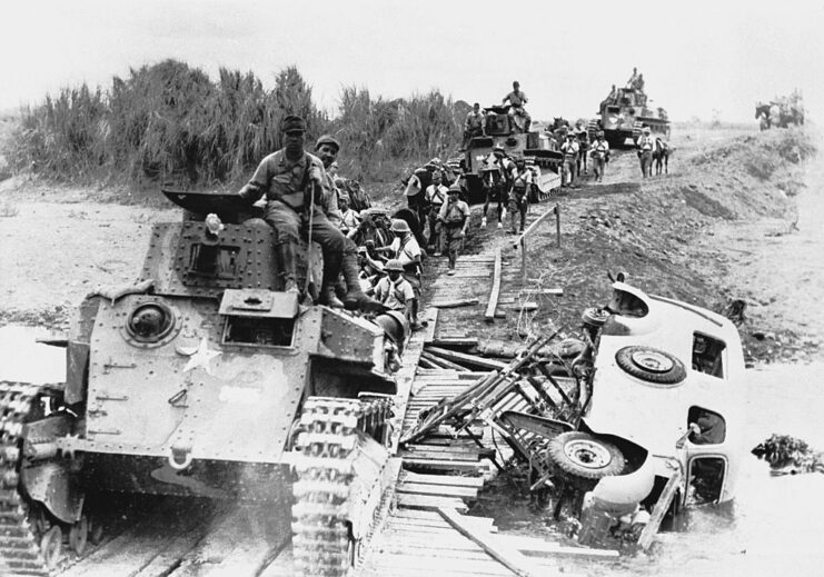 Line of Japanese tanks crossing a makeshift bridge
