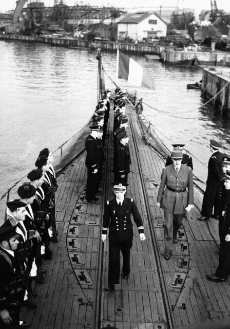 Charles de Gaulle walking by lines of sailors on the top deck of the French submarine Surcouf