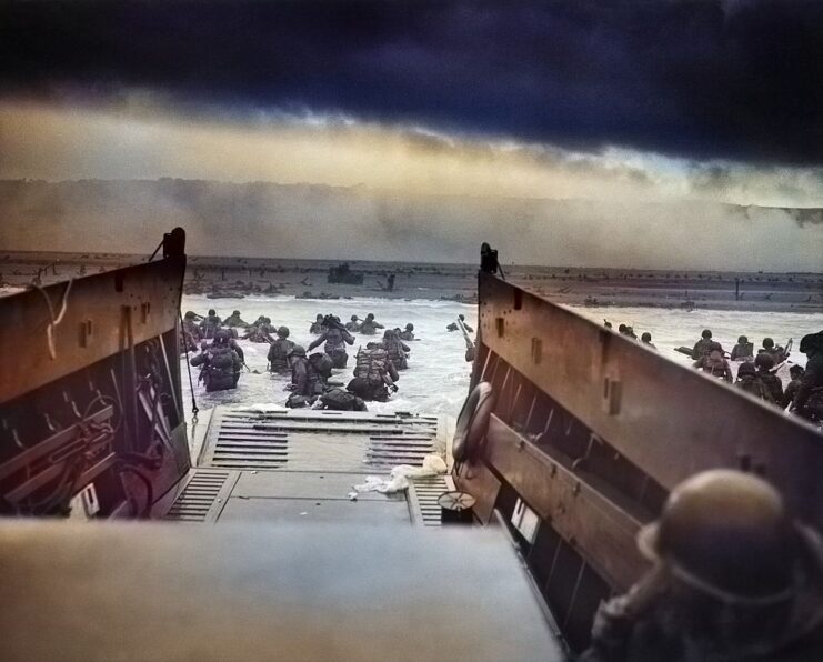 Members of Company E, 16th Infantry Regiment, 1st Infantry Division wading through the water after exiting a landing craft