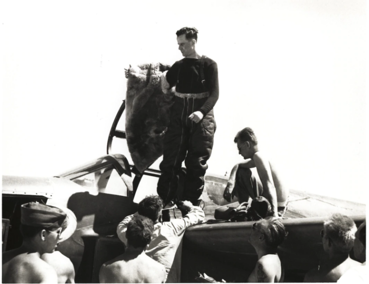 Jack Woolams climbing out of the cockpit of his aircraft while others gather around him