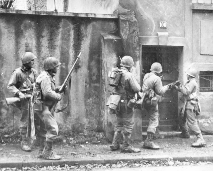 Five members of the US Third Army trying to break down a door