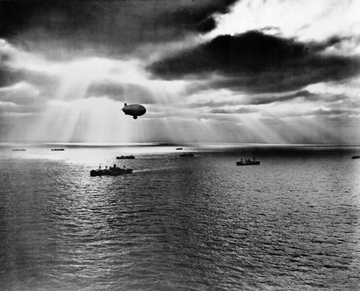Blimp hovering over Allied vessels at sea