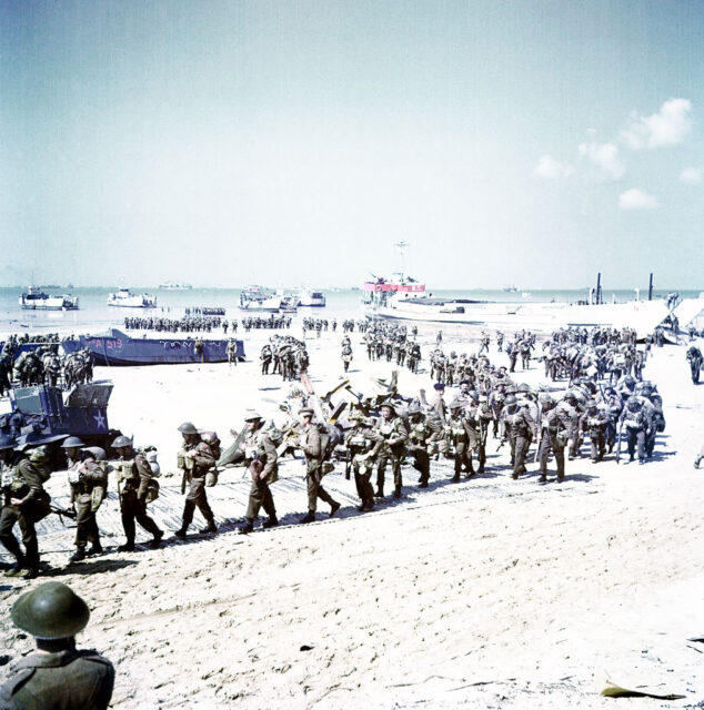 Members of the 2nd Canadian Infantry Division walking along Juno Beach