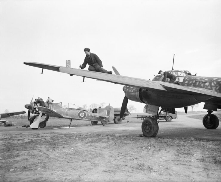 Royal Air Force (RAF) pilots standing atop the wings of a Focke Wulf Fw 190A-5 and Junkers Ju 88S-1