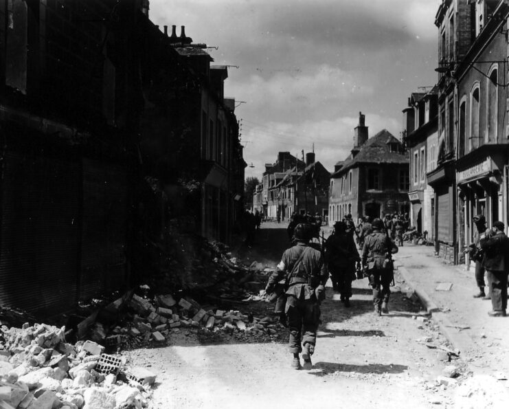 American soldiers walking along a rubble-strewn street