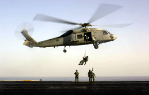 US Navy SEALs disembarking from a Sikorsky SH-60F Seahawk onto the flight deck of the USS Enterprise (CVN-65)